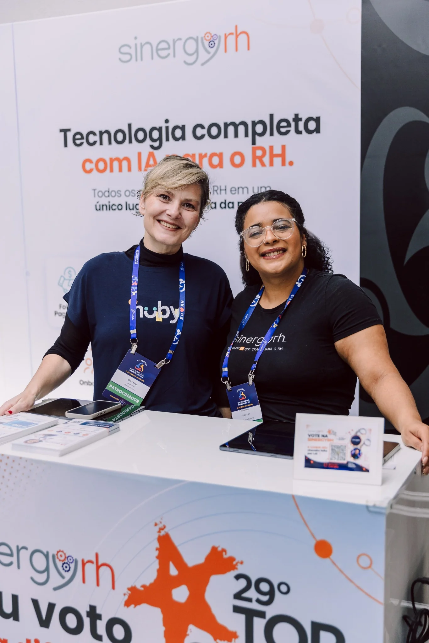 Equipe SinergyRH em evento corporativo, no estande da empresa
